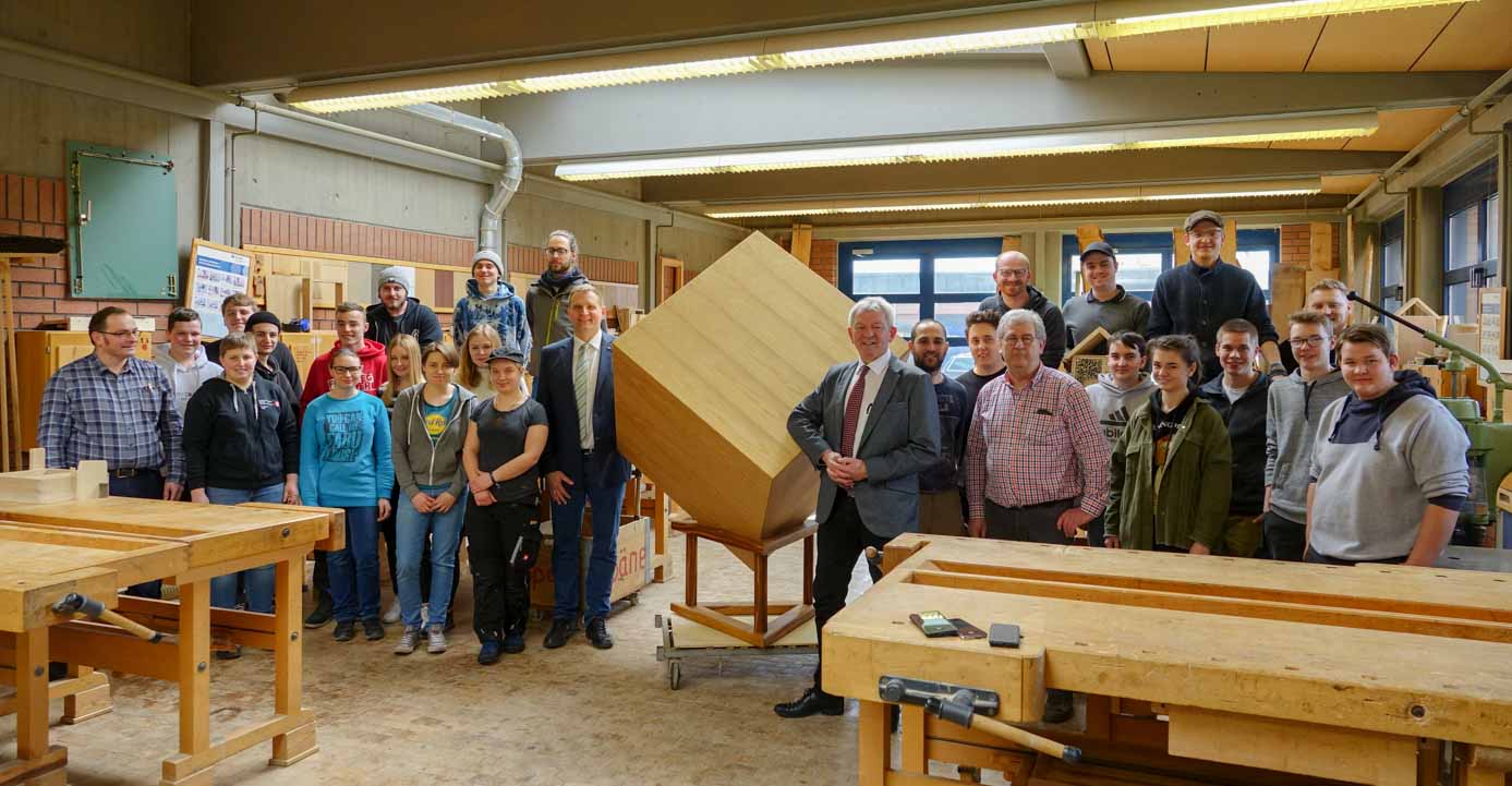 Die Berufsschule Bamberg hat den Klimaholzwürfel mit Schülerinnen und Schülern im Februar 2020 nachgebaut. Mit im Bild: Landrat Johann Kalb (rechts vom Würfel) die Lehrkräfte Baptist Mohr (rechts neben Landrat) und Dieter Schmitt (ganz links) sowie stellvertretender Schulleiter Günter Wawroschek (links vom Würfel). Foto LRA Bamberg. 