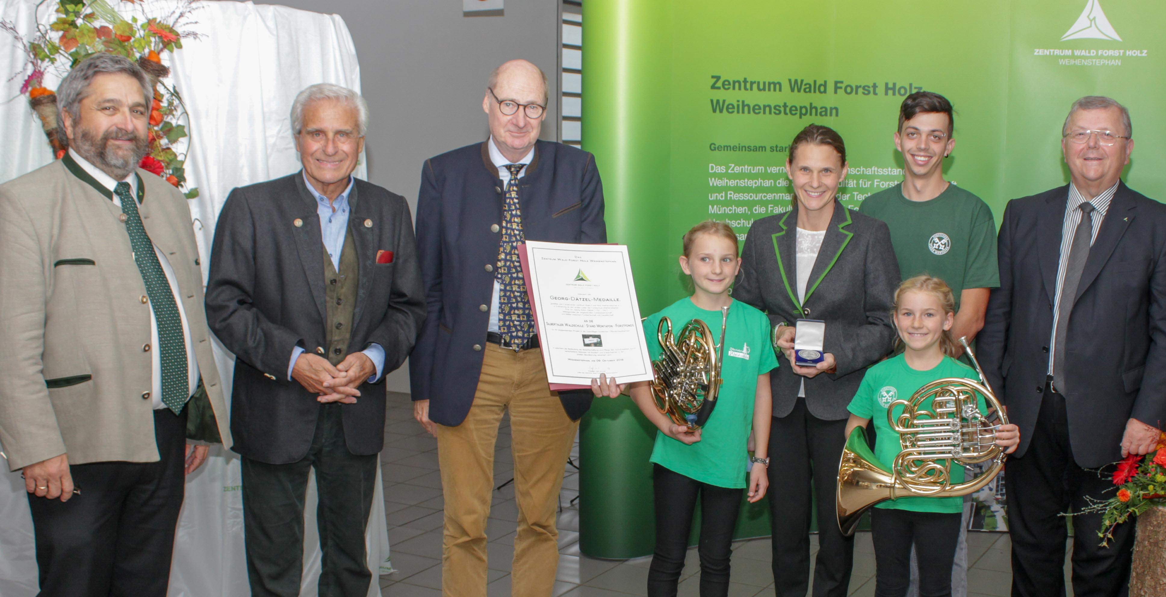 Das Zentrum wird 15 und verleiht die Georg-Dätzel-Medaille and die Silbertaler Waldschule: v.l. H. Förster, Geschäftsführer ZWFH, Festredner Professor G. Wegener, Professor R. Mosandl, 1. Vorsitzender des Fördervereins ZWFH e.V. mit Urkunde, DI S. Ackerl, Leiterin der Silbertaler Waldschule mit den Töchtern Johanna und Daniela, A. Fijatkowski, Förster und Waldpädagoge an der Silbertaler Waldschule und O. Schmidt, Präsident der LWF und Leiter des ZWFH